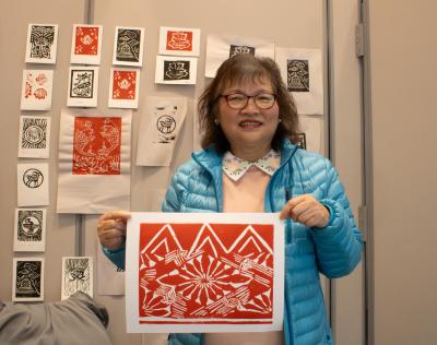 An elder displaying a lino block print