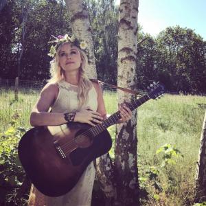 Sofia Talvik with flower wreath and a guitar